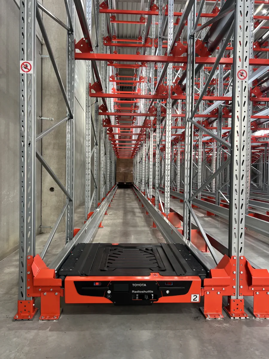 Storage shuttle inside a high-density warehouse racking aisle